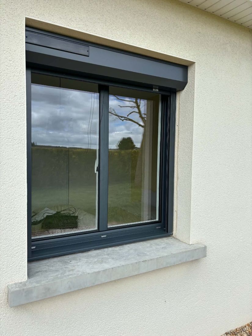 Fenêtre gris anthracite surmontée d’un volet roulant