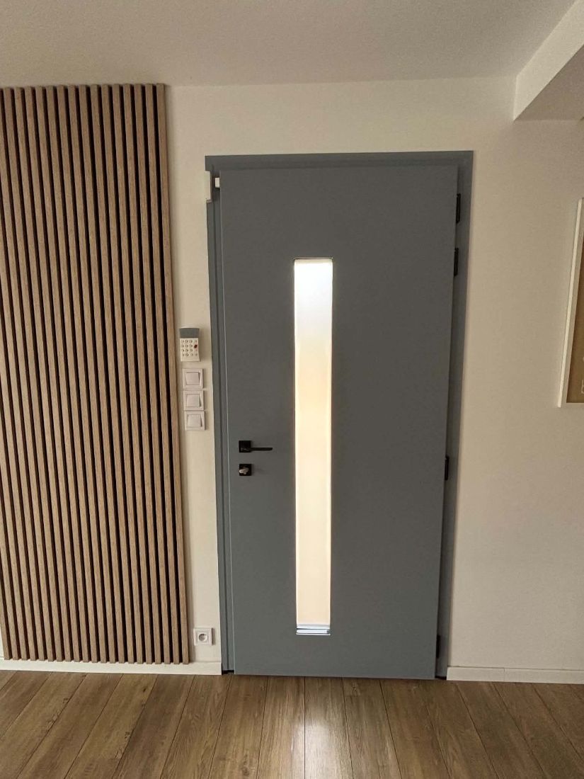 Porte d’entrée grise à fente vitrée verticale, vue de l’intérieur